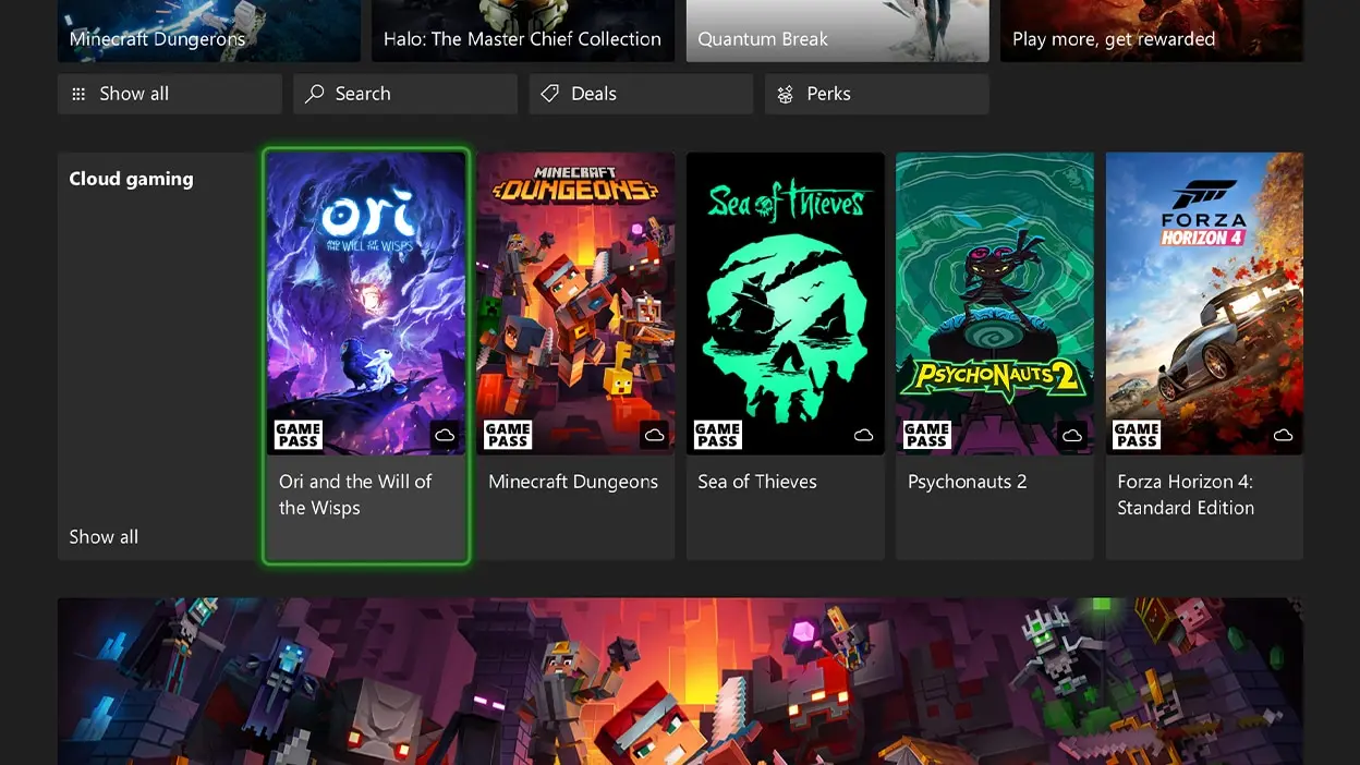 Xbox Series X console next to a PC monitor displaying game interface