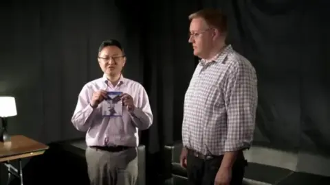 Shuhei Yoshida and Adam Boyes holding nothing at Tokyo Game Show