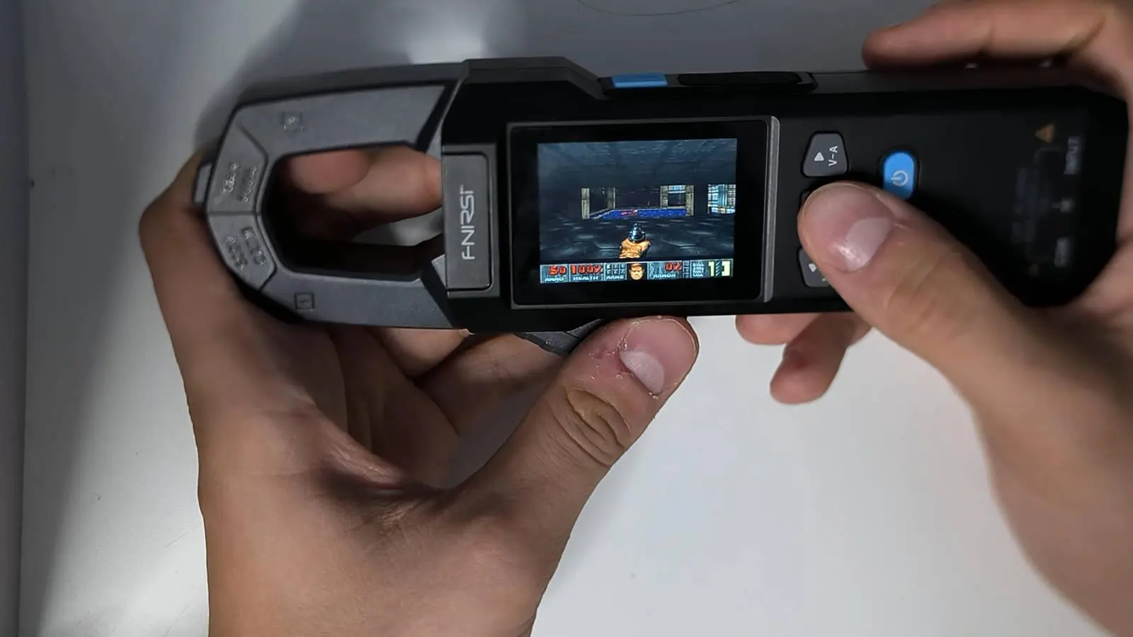 FNIRSI DMC-100 clamp meter displaying DOOM gameplay